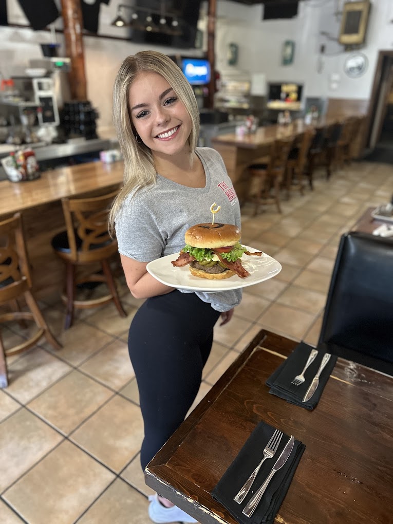 A Horseshoe server bringing out a burger